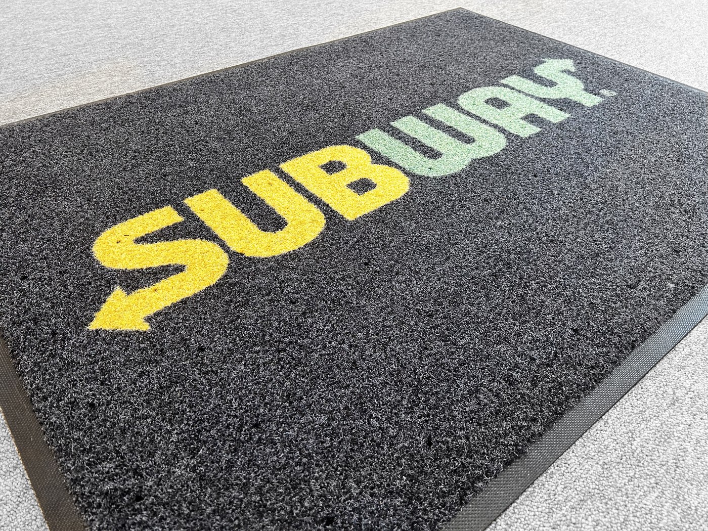 Felpudo rascador con logotipo en un acceso comercial Felpudo rascador con logotipo en un acceso comercial